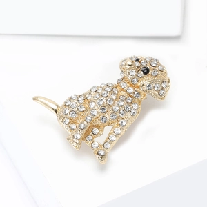 Exquise gouden hondenbroche met witte steentjes en zwarte edelsteenogen op wit