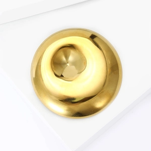 Dettaglio macro della spilla dorata in acciaio inossidabile con design a spirale lucida