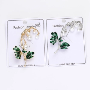 Detalle de broches de lirio de los valles en oro y plata con hojas de esmalte y perlas