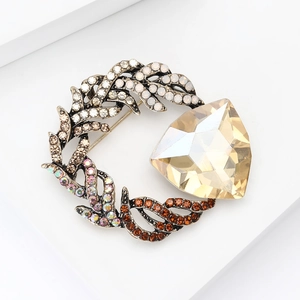 Macro detail of vintage floral brooch with champagne gold gemstone and colorful rhinestones