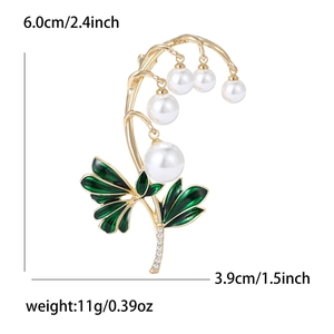 Elegante broche de lirio de los valles con perlas y esmalte verde sobre fondo blanco