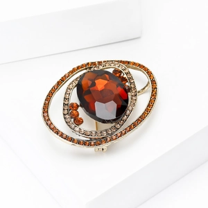 Macro shot of oval amber crystal planet brooch with multi-layer rhinestones inlay