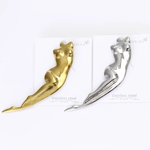Detailed macro view of gold and silver abstract body outline brooches in polished steel