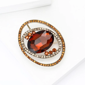 Detailed close-up of amber crystal planet brooch with vintage silver alloy setting
