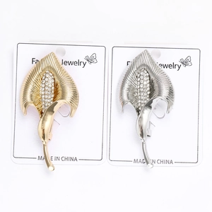 Détail de broches Calla Lily en or et argent avec pavé de cristaux sur carte blanche