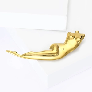 Polished gold abstract female body sculpture brooch on white minimalist background