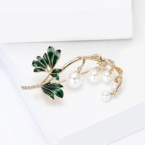 Macro de broche de lirio de los valles con hojas de esmalte verde y perlas finas