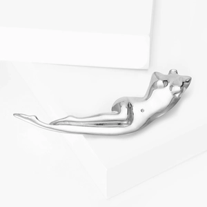 Artistic silver female sculpture brooch placed on a minimalist geometric pedestal