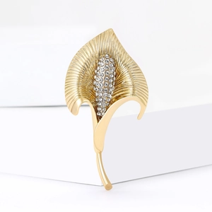 Élégante broche calla en or avec cristaux scintillants sur fond géométrique blanc