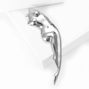 Detailed view of silver polished metal brooch with feminine silhouette sculpture design