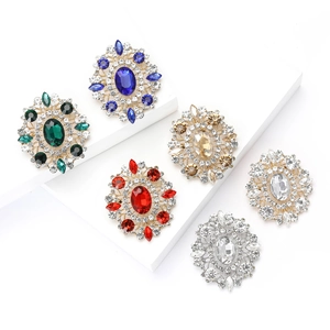 Elegant oval crystal brooches in various colors set on a classic golden alloy base