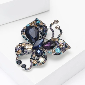 Elegant silver butterfly brooch with colorful rhinestones on a white geometric background