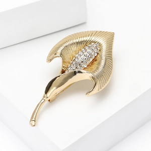 Vue détaillée de la broche fleur de calla dorée avec strass brillants et texture brossée