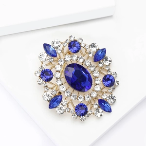 Macro detail of royal vintage brooch with large oval blue rhinestone and gold filigree