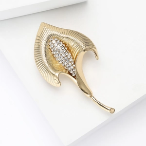 Vue détaillée de l'élégante broche calla en métal doré ornée de strass brillants de luxe