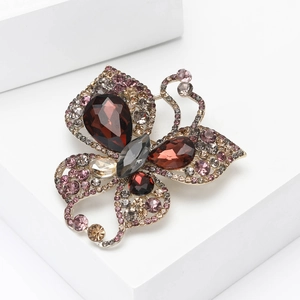 Macro detail of butterfly brooch showing colorful crystals and fine gold plating