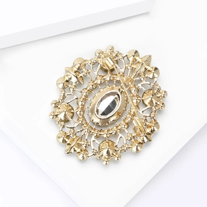Close-up of the vintage golden brooch back featuring detailed镂空patterns and safety pin clasp