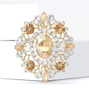 Macro shot of large champagne oval rhinestone brooch with gold mandala crystal pattern