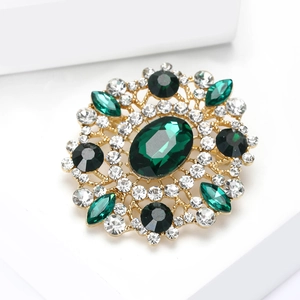 Detailed macro of vintage emerald flower brooch with crystal inlay and gold plating