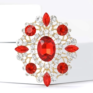 Macro shot of vintage hollow gold brooch with large oval red ruby and sparkling rhinestones