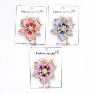 Detail of floral brooches featuring gold plating, rhinestones, and oil-dripping enamel process