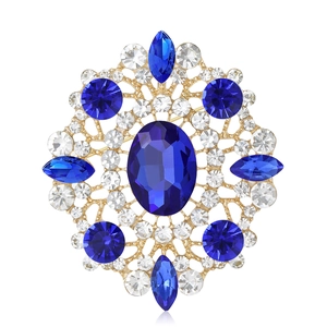 Elegant vintage gold brooch with large oval blue gemstone and white rhinestones