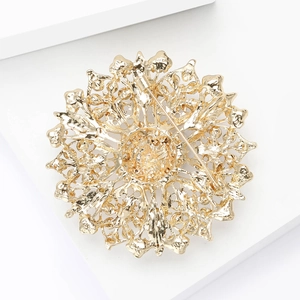 Macro view of gold flower brooch back showing the secure safety pin clasp mechanism