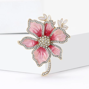 Exquisite pink enamel flower brooch with sparkling rhinestone accents on gold branches