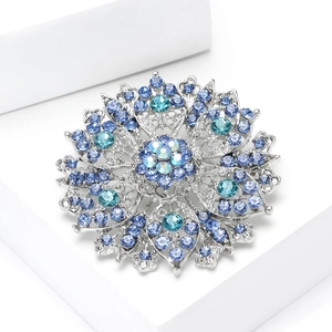 Close-up of luxury hollow crystal flower brooch with blue and teal gradient rhinestones