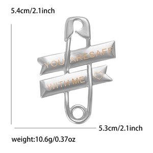 Detail view of silver safety pin brooch with YOU ARE SAFE WITH ME engraving and heart icon