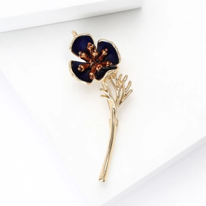 Detailed view of an elegant blue poppy brooch with gold base and enamel flower petals