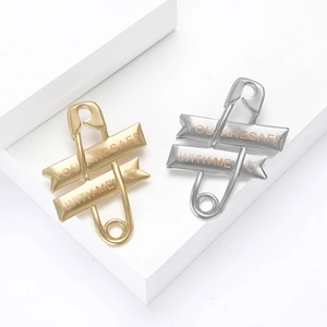 Minimalist safety pin brooches in gold and silver with engraved You Are Safe With Me text