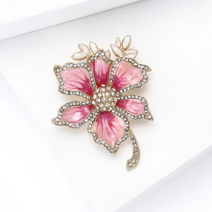 Macro view of pink enamel flower brooch with sparkling cubic zirconia and gold stem detail