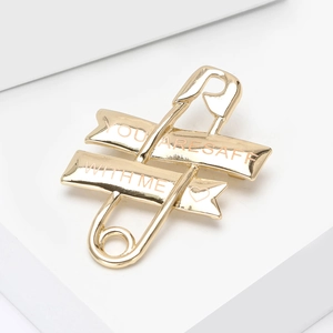 Polished gold safety pin brooch with You Are Safe With Me engraving and heart icon
