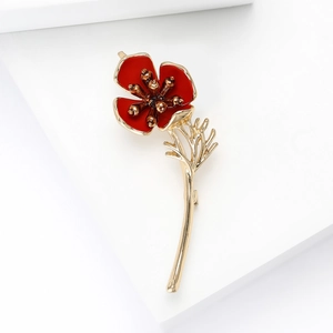 Detailed close-up of a red poppy flower brooch with gold plating and enamel finish