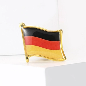 Macro detail of wave-shaped German flag lapel pin with glossy enamel and golden trim