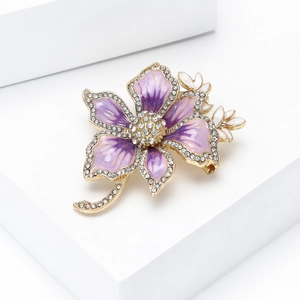 Macro detail of luxury flower brooch with purple enamel petals and crystal pavé on gold base