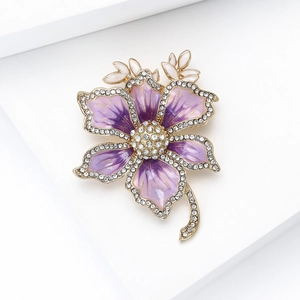 Macro shot of purple enamel flower brooch with sparkling rhinestones and gold stem