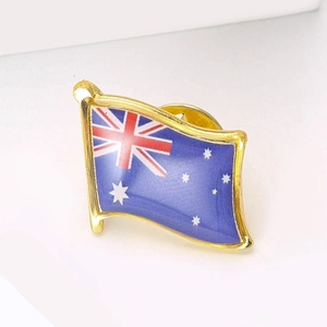 Australian flag brooch with wavy design and golden metal edges on a white background
