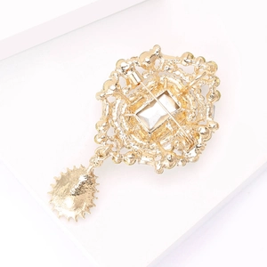 Detail view of the vintage gold brooch back featuring filigree craft and safety pin clasp