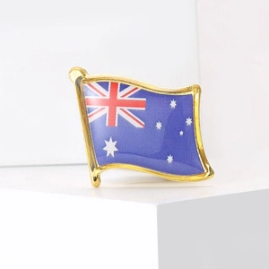 Detailed view of the Australian flag brooch with golden edges on a white geometric stand