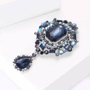 Detailed macro view of retro glass brooch with navy blue rectangle gem and drop pendant