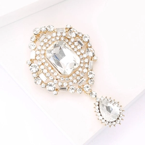 Macro shot of vintage gold brooch with clear crystals and a large teardrop pendant detail