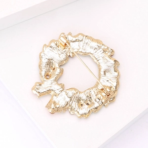 Detail of gold-plated alloy brooch featuring irregular wreath texture and secure pin clasp