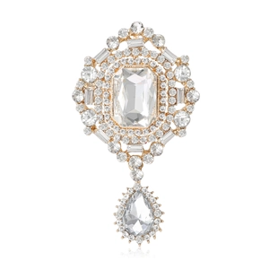 Vintage gold crystal brooch featuring a large emerald-cut stone and pear-shaped drop pendant