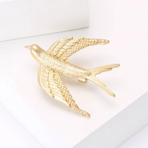 Elegant gold flying swallow bird brooch for suits and coats with detailed feather texture