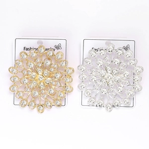 Détail de broches de luxe en strass soleil doré et argenté avec design ajouré multicouche