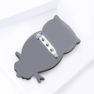 Vue arrière d'une broche hibou en acrylique noir avec fermeture à épingle de sûreté en argent