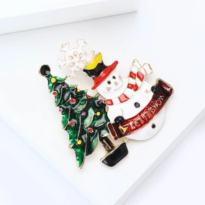 Broche de Noël en émail doré avec bonhomme de neige et sapin sur un support blanc élégant