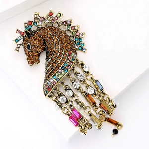 Macro detail of horse head brooch with multi-colored rhinestones and long gold chains
